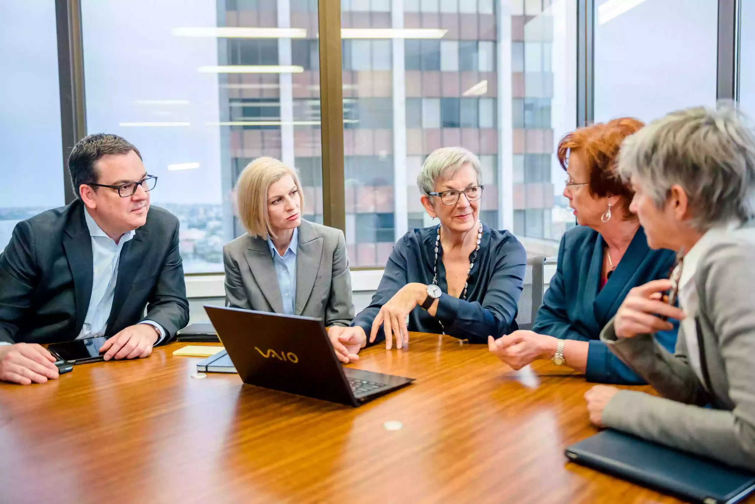 a group of women and a man at a boardroom meeting as photographed by a sydney business photographer